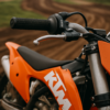 KTM crossmotor met close-up van een hoogwaardige gashendel op een modderig crosscircuit